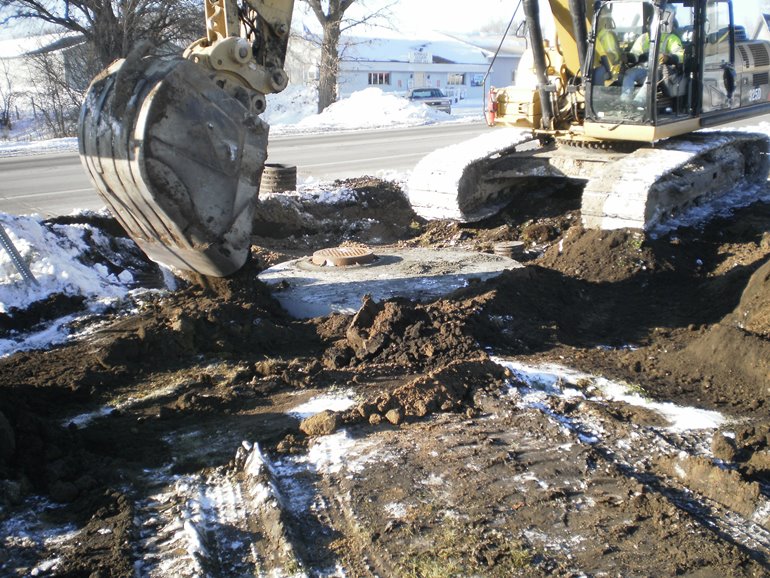 construction equipment leveling dirt around newly constructed culvert 