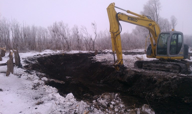 Excavator clearing out cutoff channel